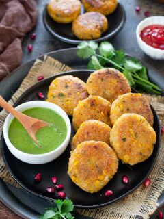 Corn kebabas on a tray with green chutney