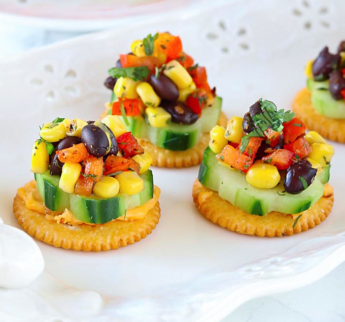 Cracker bites topped with salsa on a white plate