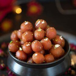 Angoori gulab jamun in a black bowl
