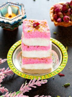 Layered coconut burfi stacked on a plate