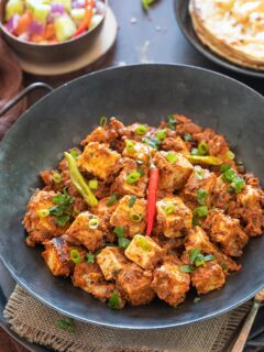 Tawa paneer in a bowl garnished with scallions